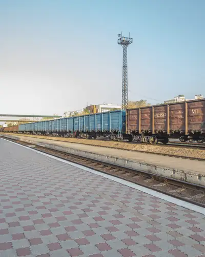 Freight wagons on the tracks beside an empty station platform